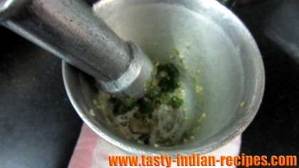 Crush giner and green chillies with mortar and pestle