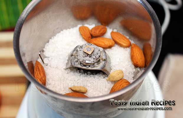 Put sugar, almonds and green cardamom in mixer grinder