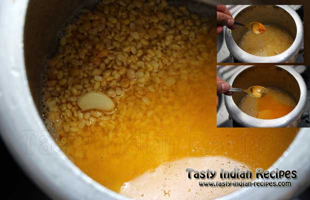 Pressure Cook Dal by adding red chilli powder, turmeric powder, coriander powder, whole pods of garlic and salt to taste