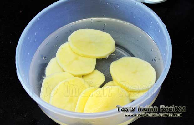 Chop the potatoes in medium sized round slices and put in water
