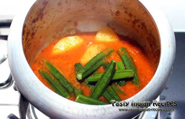 Add bhindi along with one chopped onion and mix well with potatoes